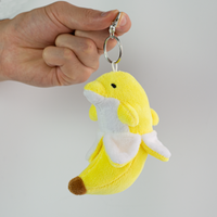 Bandan the Banana Dolphin Plush Keychain, dangling from hand