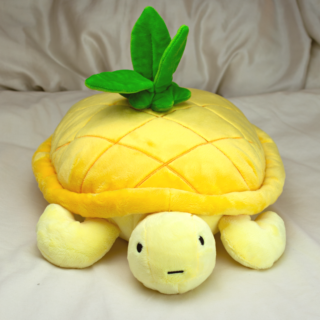 Bolo the Pineapple Turtle Plush, front view on bed