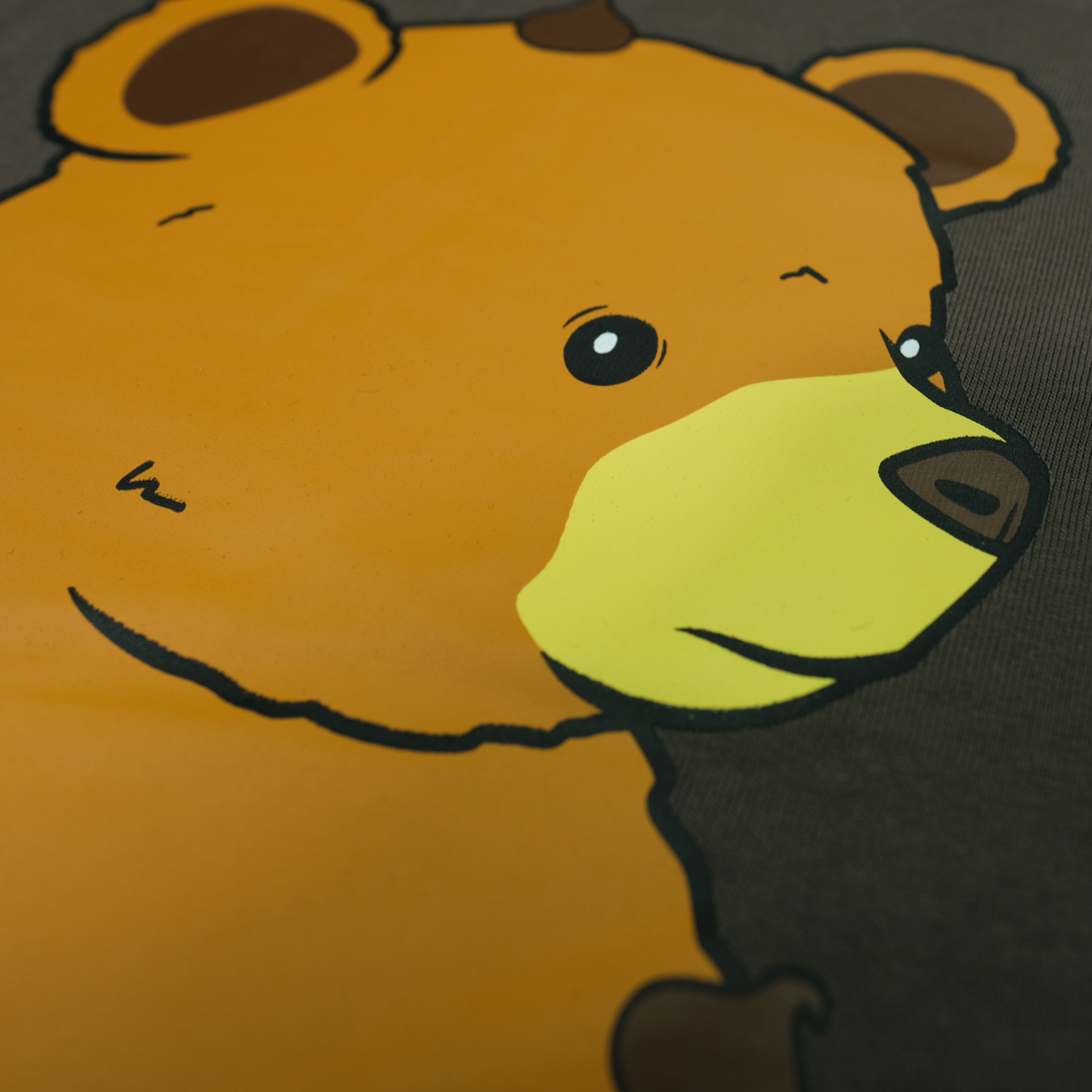 Close-up of Chip the Cookie Bear's face on the Espresso tee back print