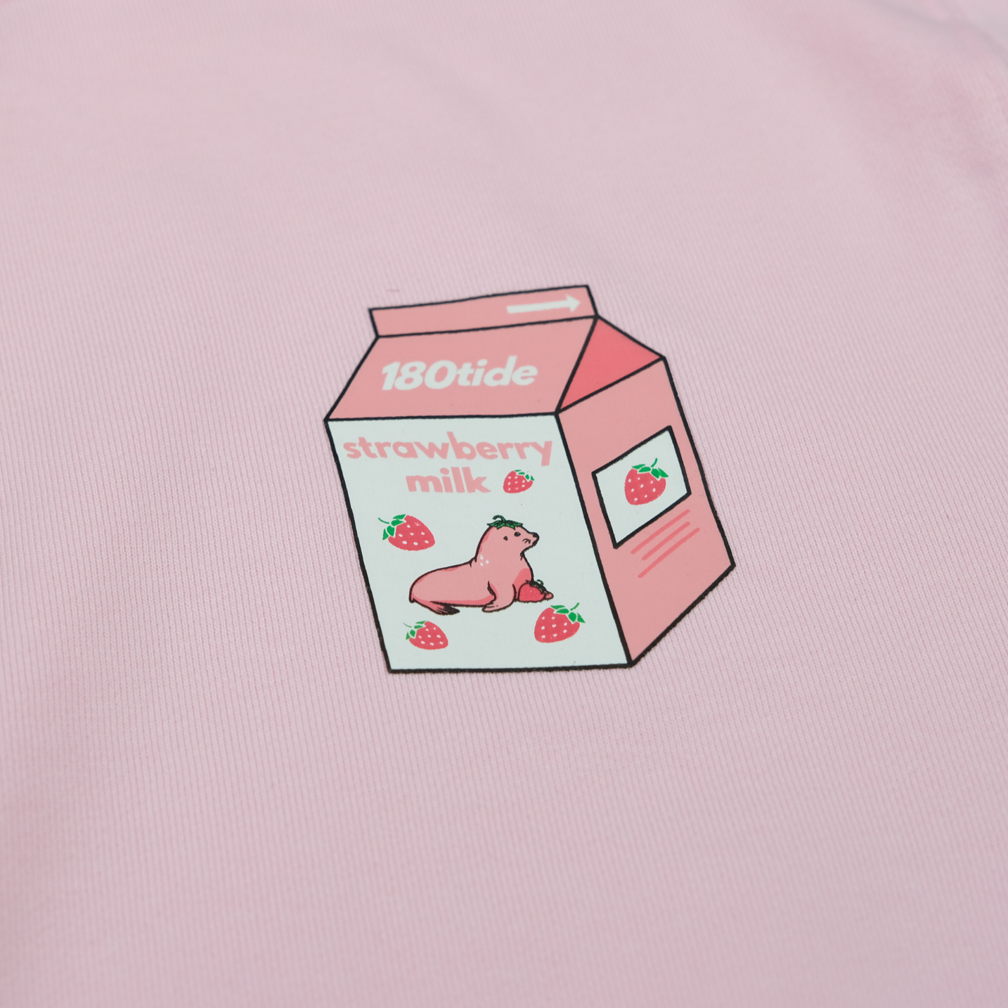 Close-up of Kelsa the Strawberry Seal in the strawberry milk carton chest print on the Kelsa Strawberry Seal Milk Crewneck