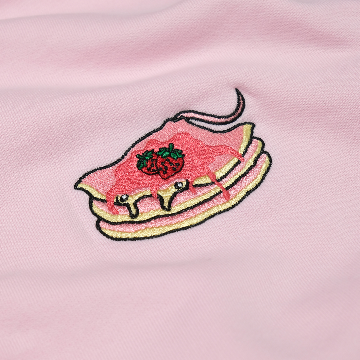 Close-up of the Strawberry Stacks chest embroidery on the Strawberry Pink hoodie