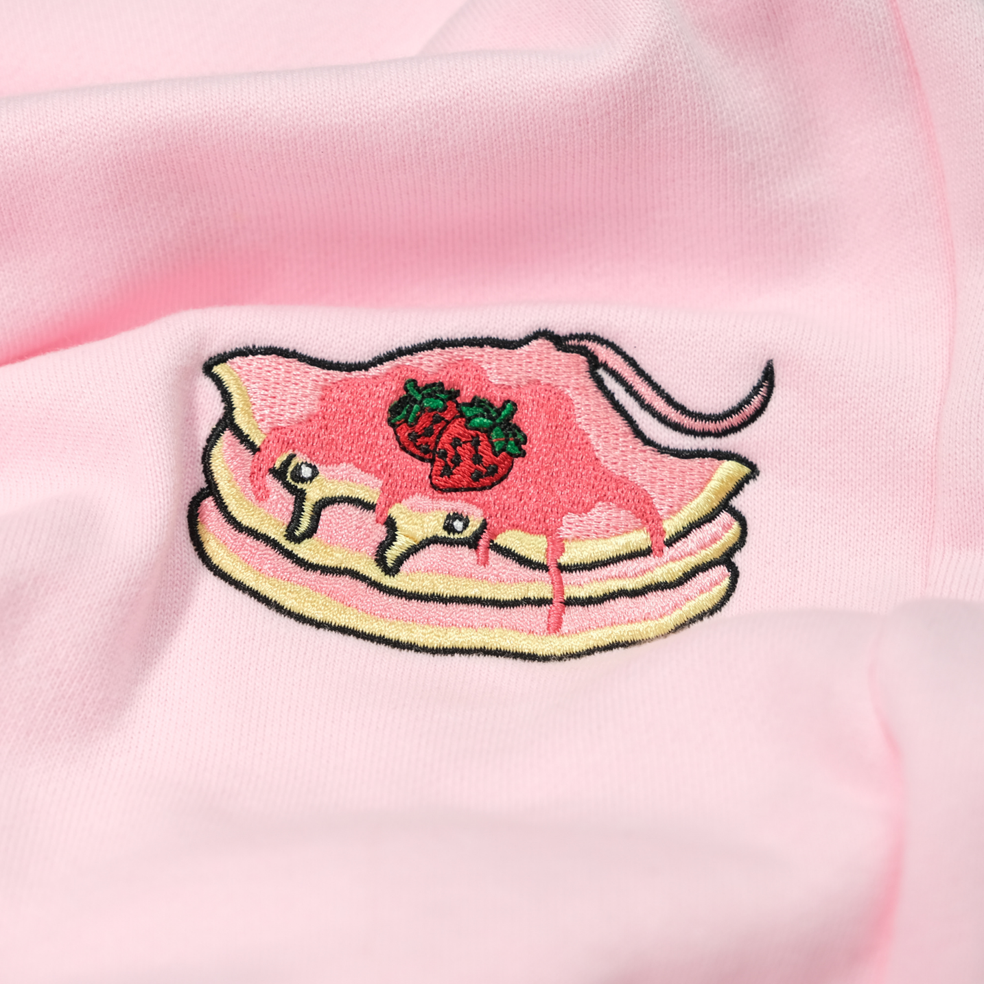 Close-up of the Strawberry Stacks thigh embroidery on the Strawberry Pink sweatpants