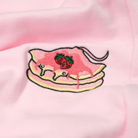 Close-up of the Strawberry Stacks thigh embroidery on the Strawberry Pink sweatpants