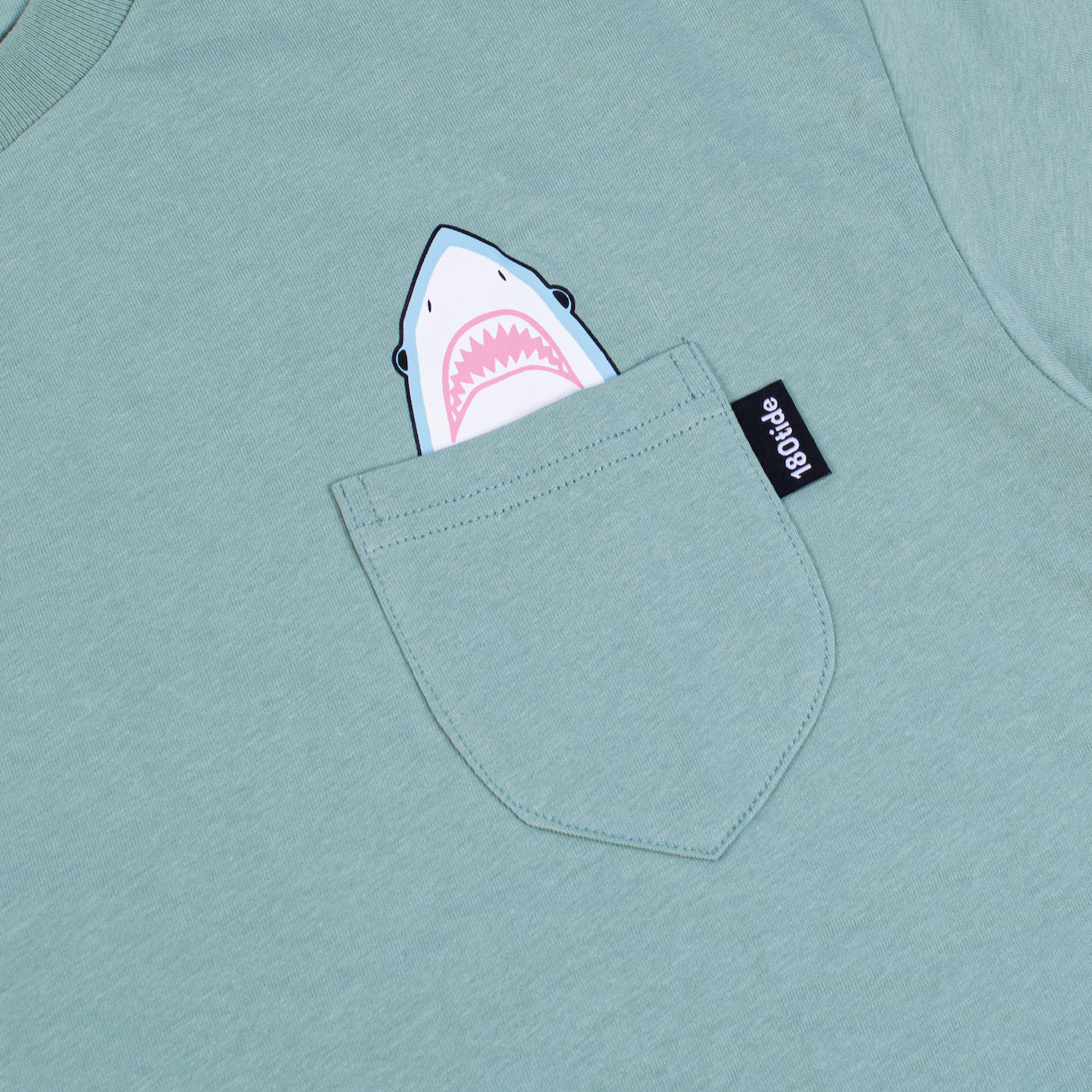 Shark wearing rubber ducky floatie sage green pocket tee. 