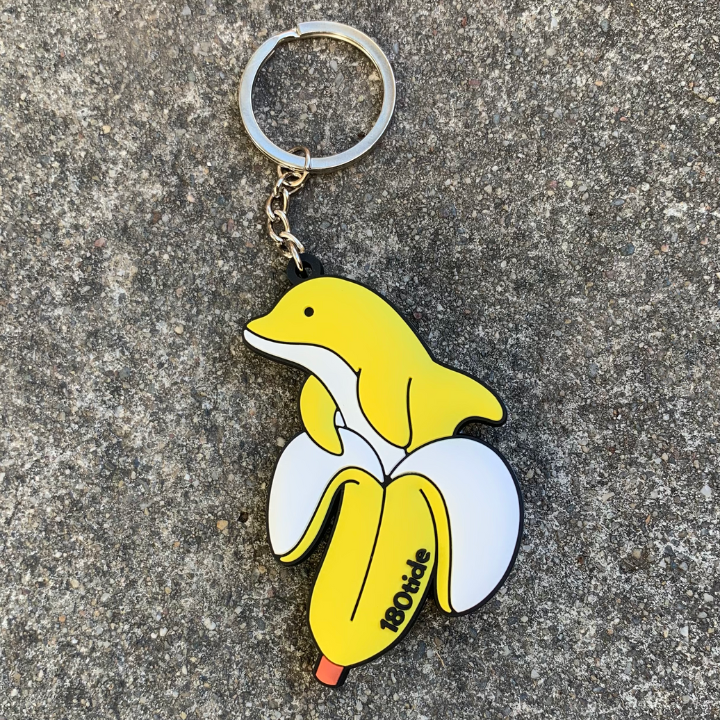 Bandan the Banana Dolphin Rubber Keychain, lifestyle on pavement
